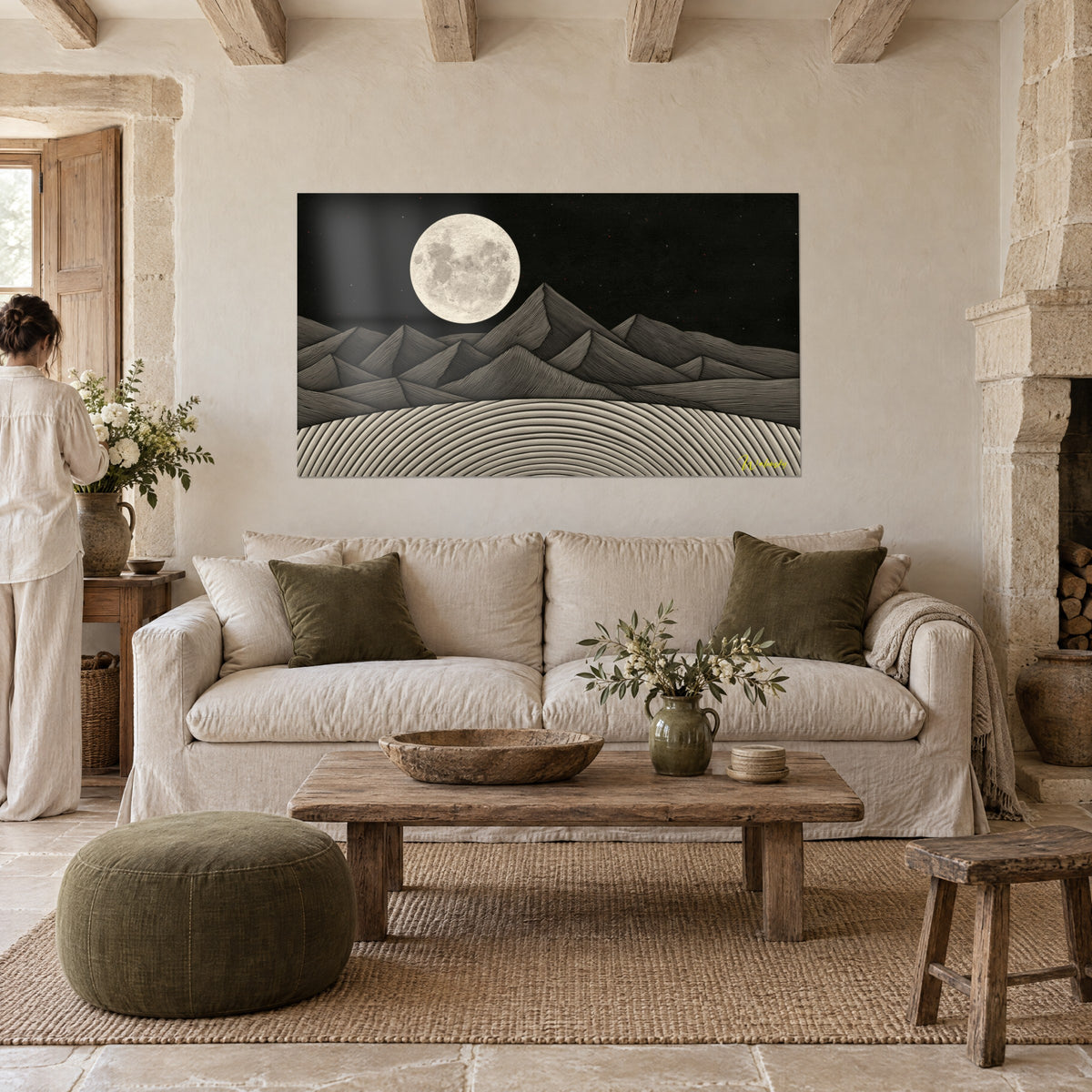 Tableau pleine lune ivoire sur crêtes noires et grises, lignes gravées, femme de dos, au-dessus d'un canapé dans un salon lumineux