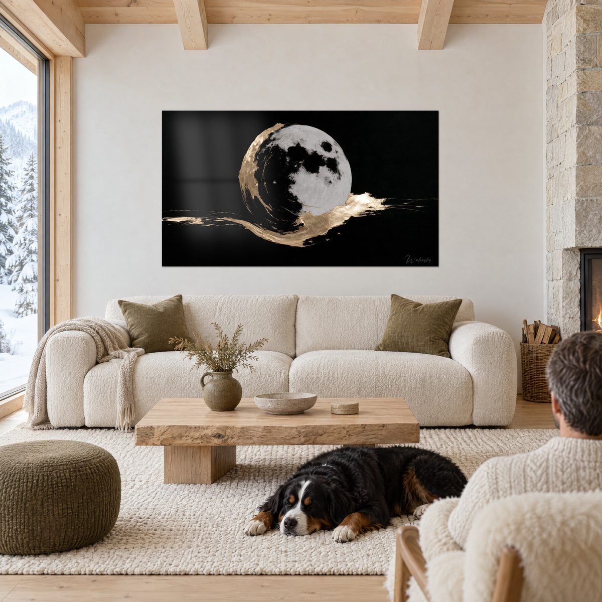 Tableau pleine lune grise cratérisée sur fond noir, traînées d'or, deux personnes de dos et un chien, au-dessus d'un canapé dans un salon lumineux