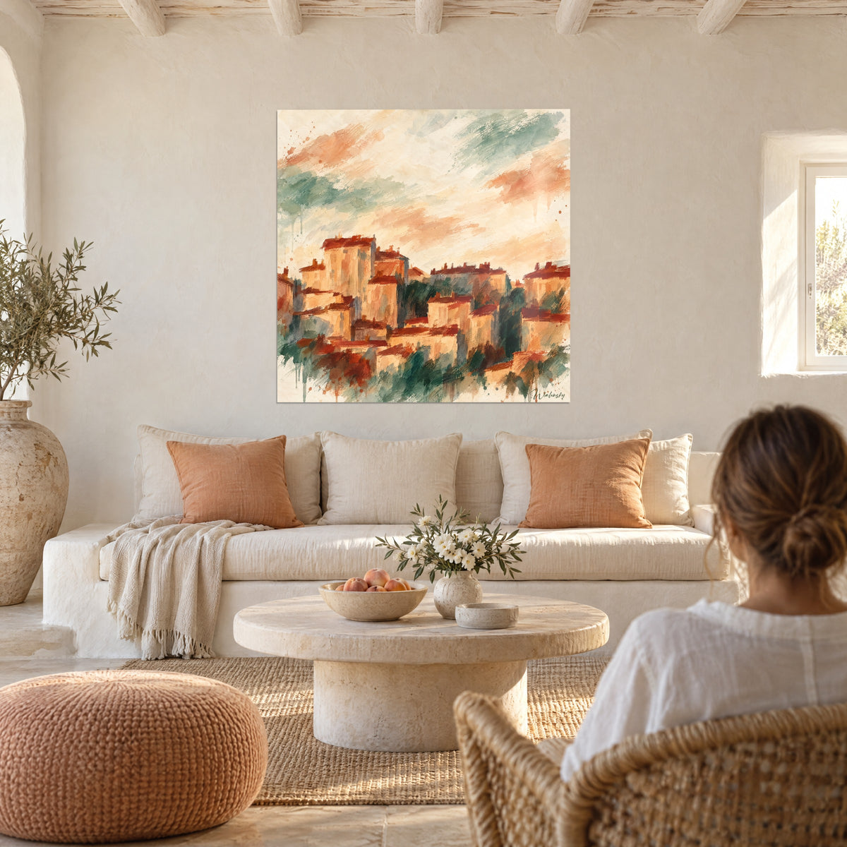 Quadro borgo arroccato dai tetti color ruggine e facciate ocra sotto un cielo salvia, sopra un divano in un soggiorno luminoso