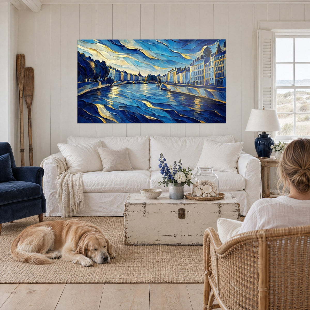 Gemälde Fluss in tiefblauen Wellen mit goldenen Adern, Haussmann-Kais im Hintergrund, liegender Retriever, über einem Sofa in einem hellen Wohnzimmer