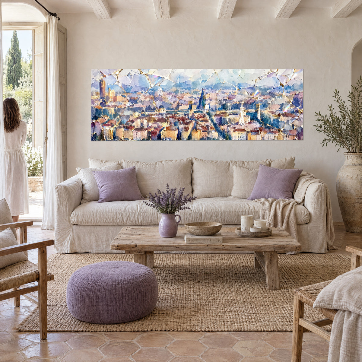 Gemälde Panorama der Lyoner Dächer in Ocker und Blau, weißer Kirchturm und goldene Maserung, über einem Sofa in einem hellen Wohnzimmer