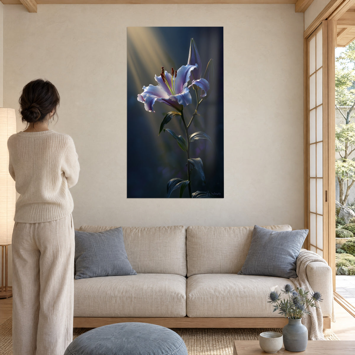 Quadro giglio bianco venato di azzurro lavanda, stami bruni, fascio dorato su sfondo notturno, sopra un divano in un soggiorno luminoso