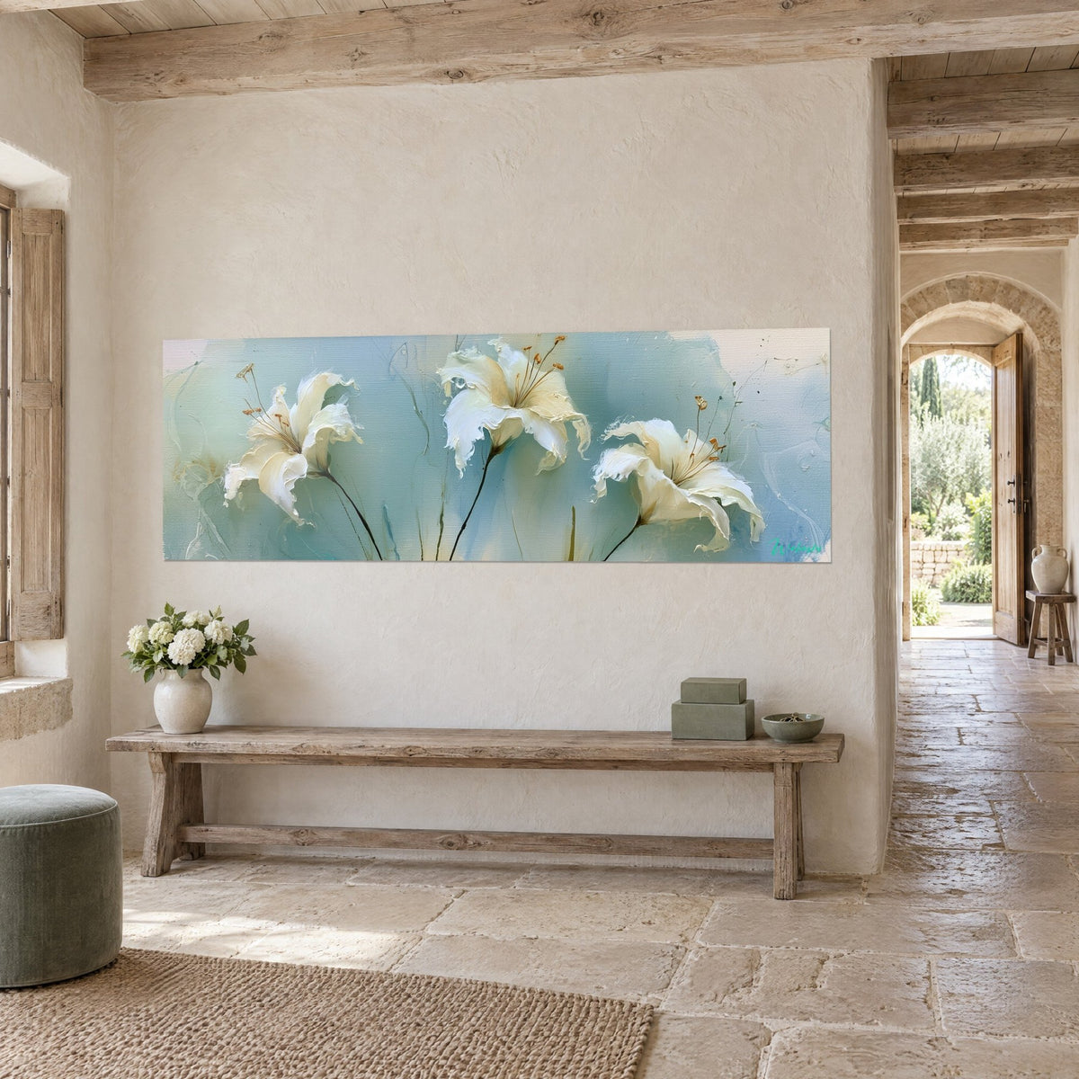 Tableau trio de lis ivoire aux tiges noires, sur fond bleu céladon et crème, accroché dans une maison en pierre, vue de trois-quarts