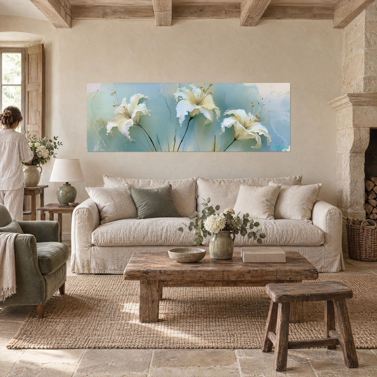 Tableau lys blancs aux pétales froissés sur fond bleu poudré, étamines ocre, personne de dos, au-dessus d'un canapé dans un salon lumineux