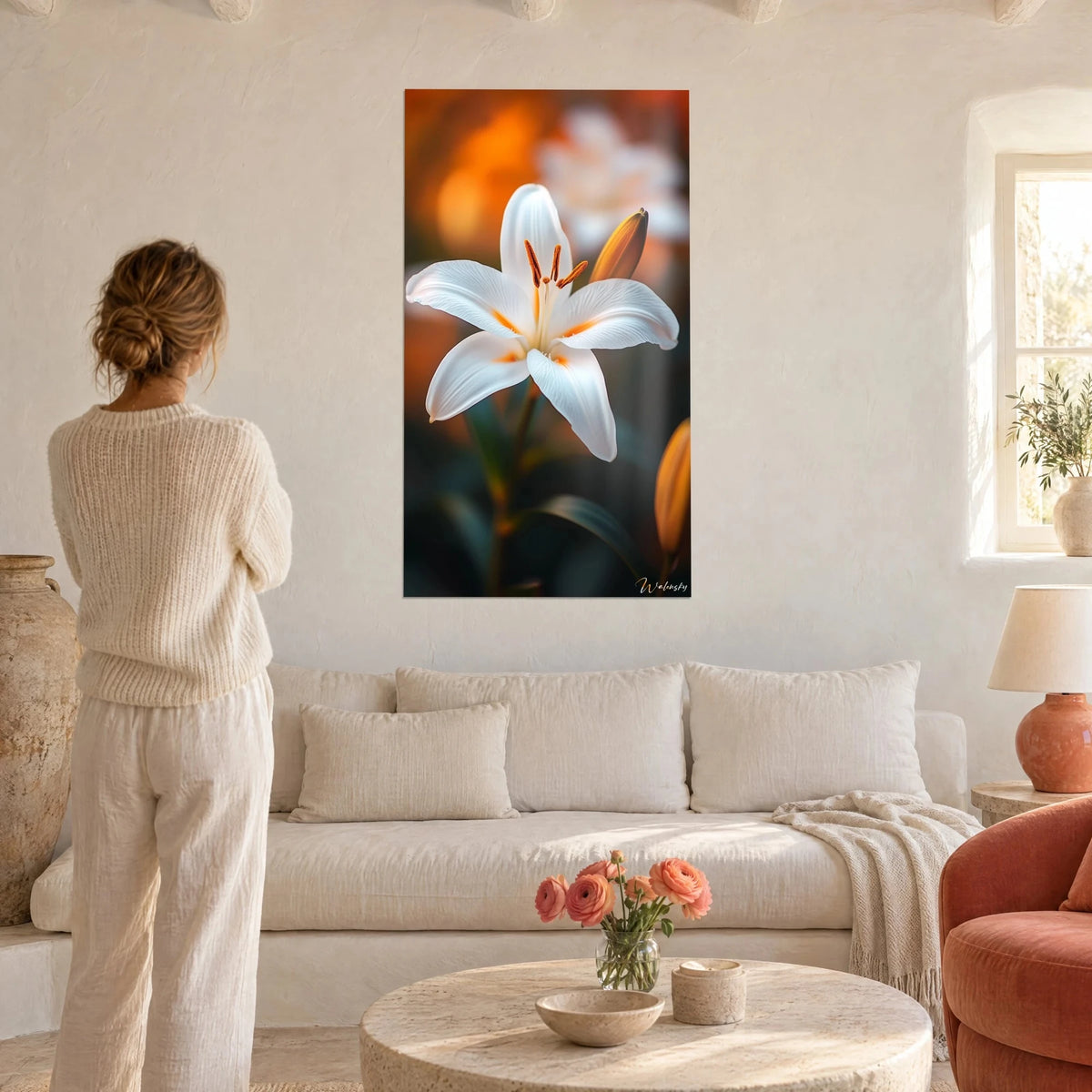 Gemälde weiße Lilie in voller Blüte, orangefarbene Staubgefäße auf unscharfem Bernsteinhintergrund, über einem Sofa in einem hellen Wohnzimmer