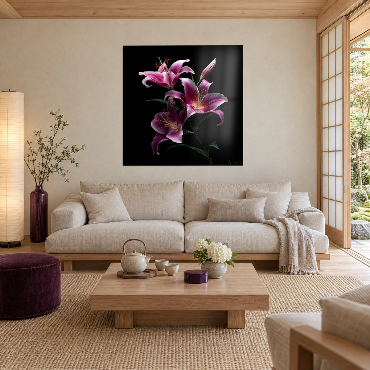 Quadro giglio fucsia su fondo nero, petali rosa pallido e stami rossi ricurvi, sopra un divano in un soggiorno luminoso