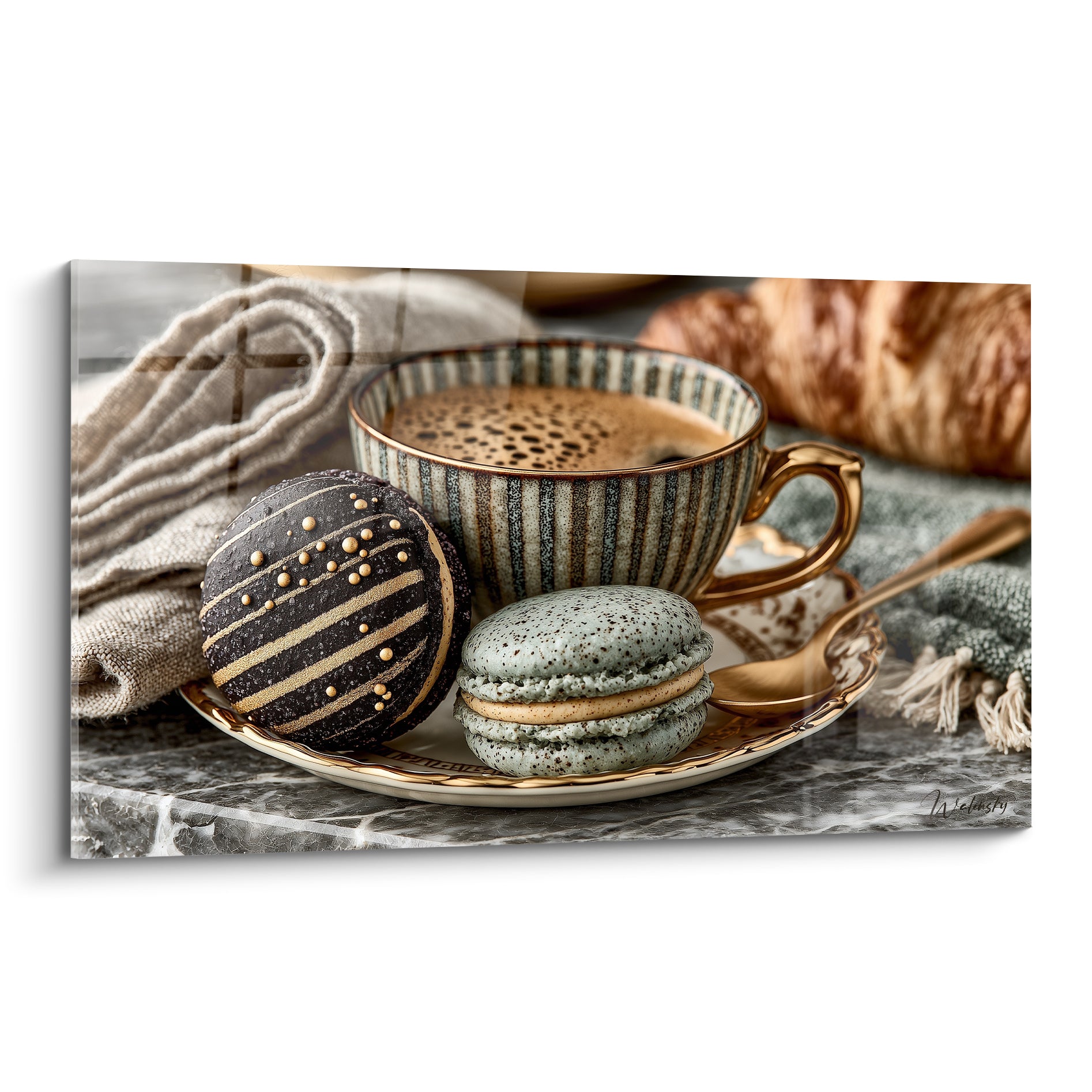 Macarons anthracite doré et vert sauge sur soucoupe dorée près d'une tasse rayée fumante
