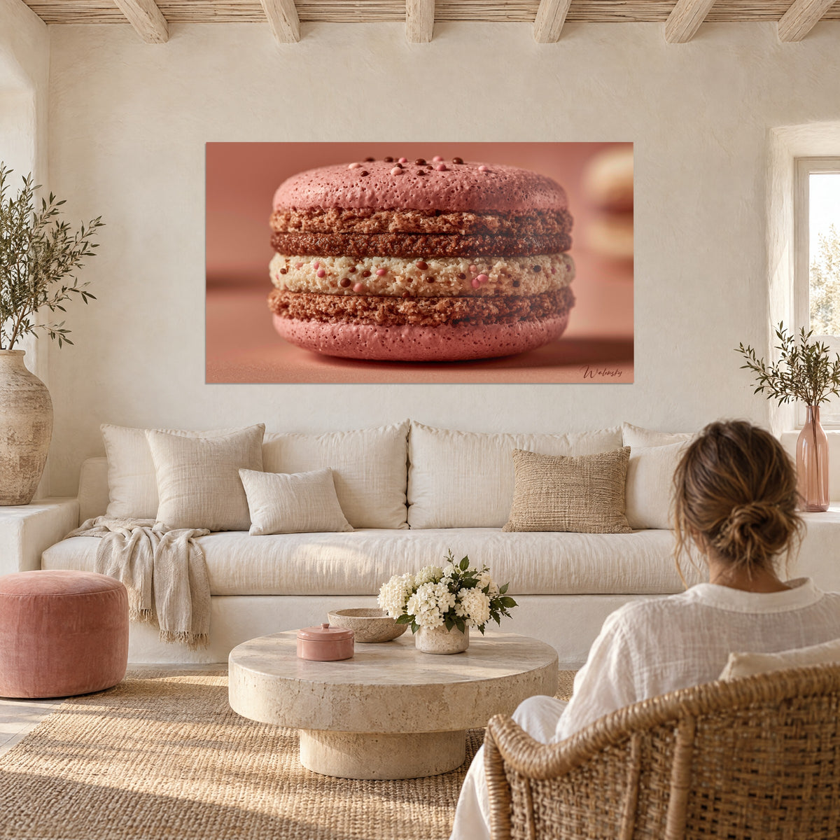 Wall art raspberry-pink macaron with granular shells and ivory cream, above a sofa in a bright living room