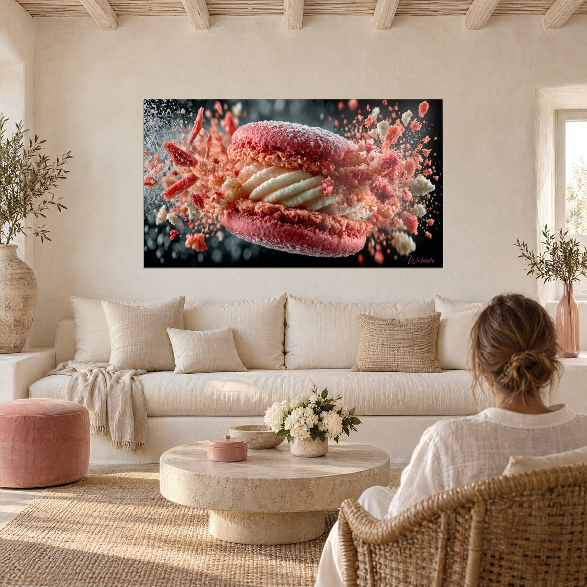 Tableau macaron rose framboise éclatant en miettes sur fond noir, ganache blanche striée, au-dessus d'un canapé dans un salon lumineux