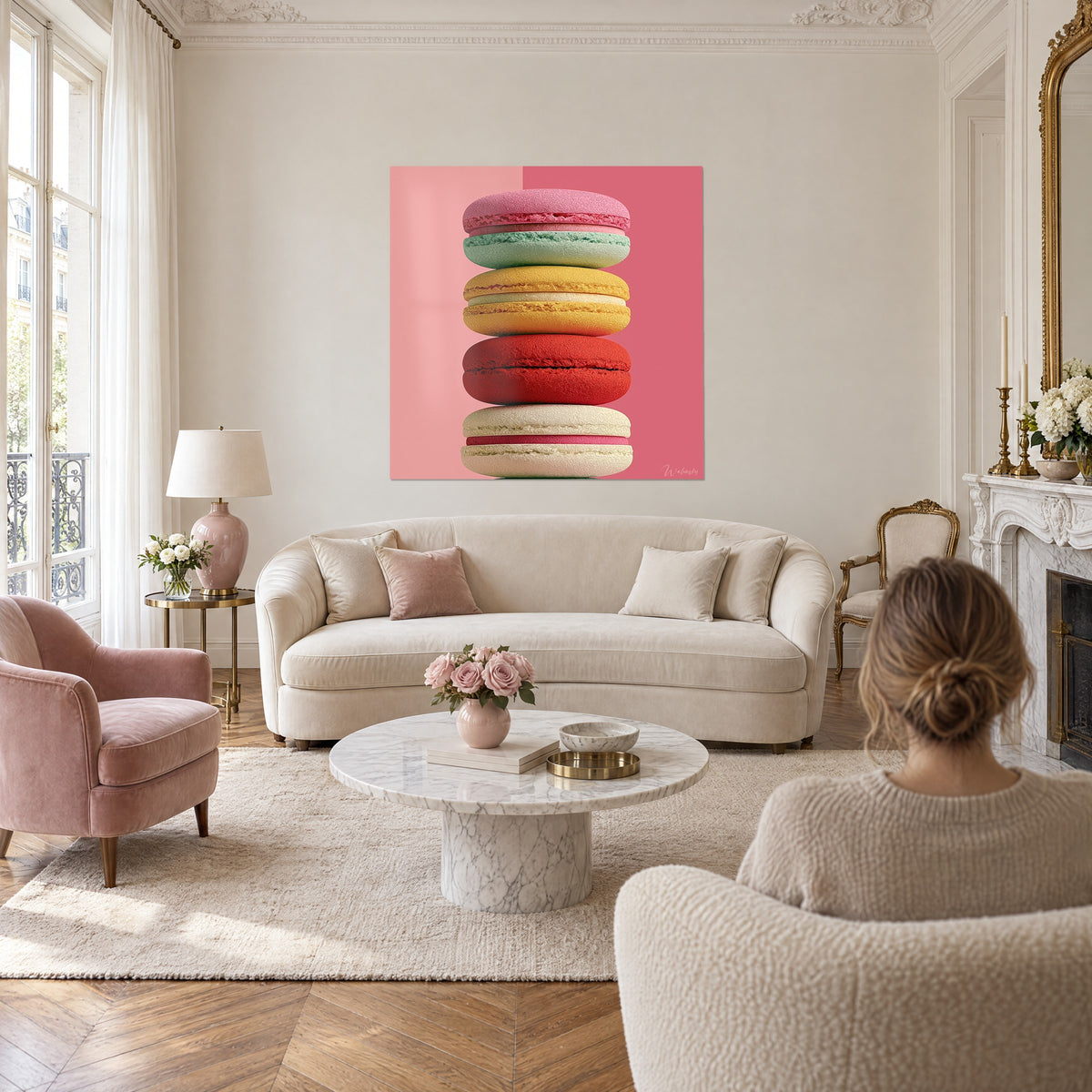 Quadro di macarons impilati rosa e verde menta su sfondo rosa pallido, sopra un divano in un soggiorno luminoso