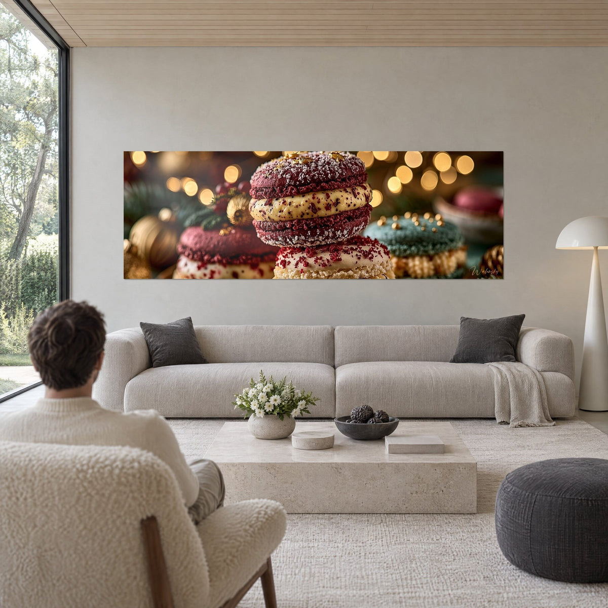 Tableau macaron grenat givré empilé, crème ivoire mouchetée de rouge et boules dorées floues, au-dessus d'un canapé dans un salon lumineux