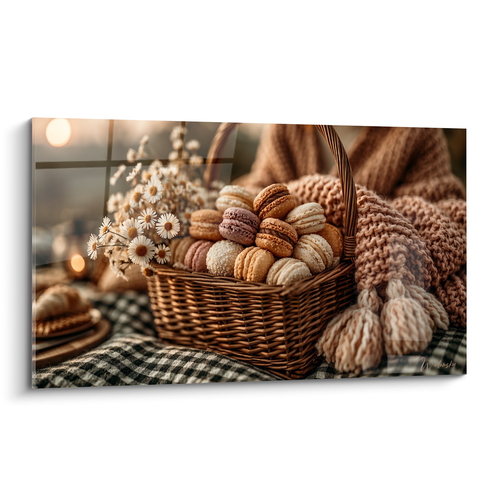 Macarons beige, marron et mauve empilés dans un panier tressé aux côtés de marguerites blanches