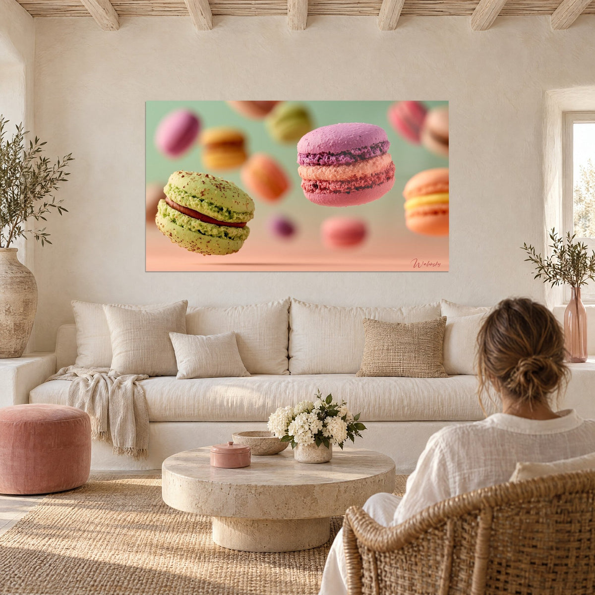 Tableau macarons pistache et mauve en lévitation sur fond sauge, fondu rose pêche, au-dessus d'un canapé dans un salon lumineux
