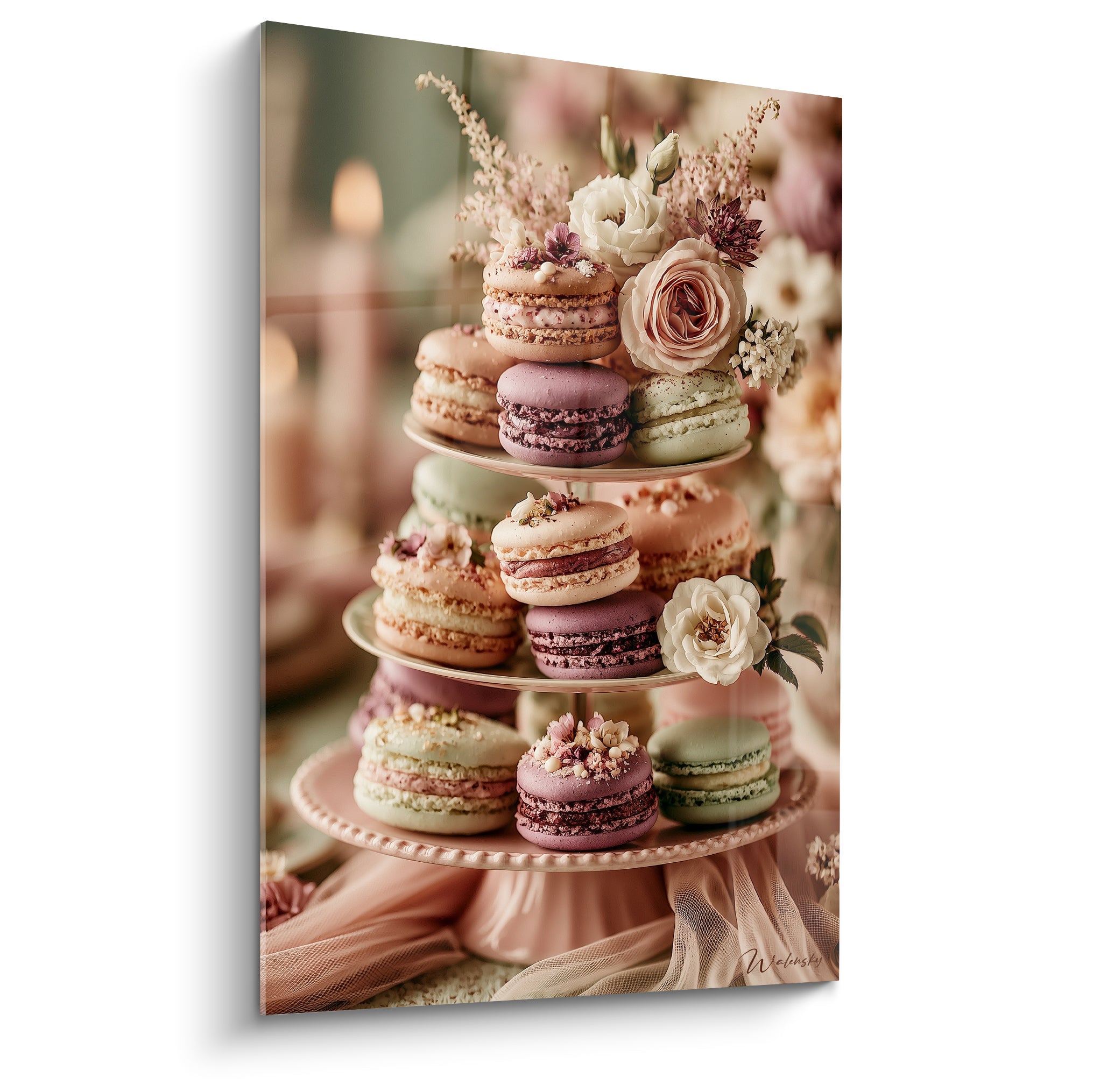 Macarons rose poudré et mauve empilés sur présentoir fleuri de roses blanches et roses