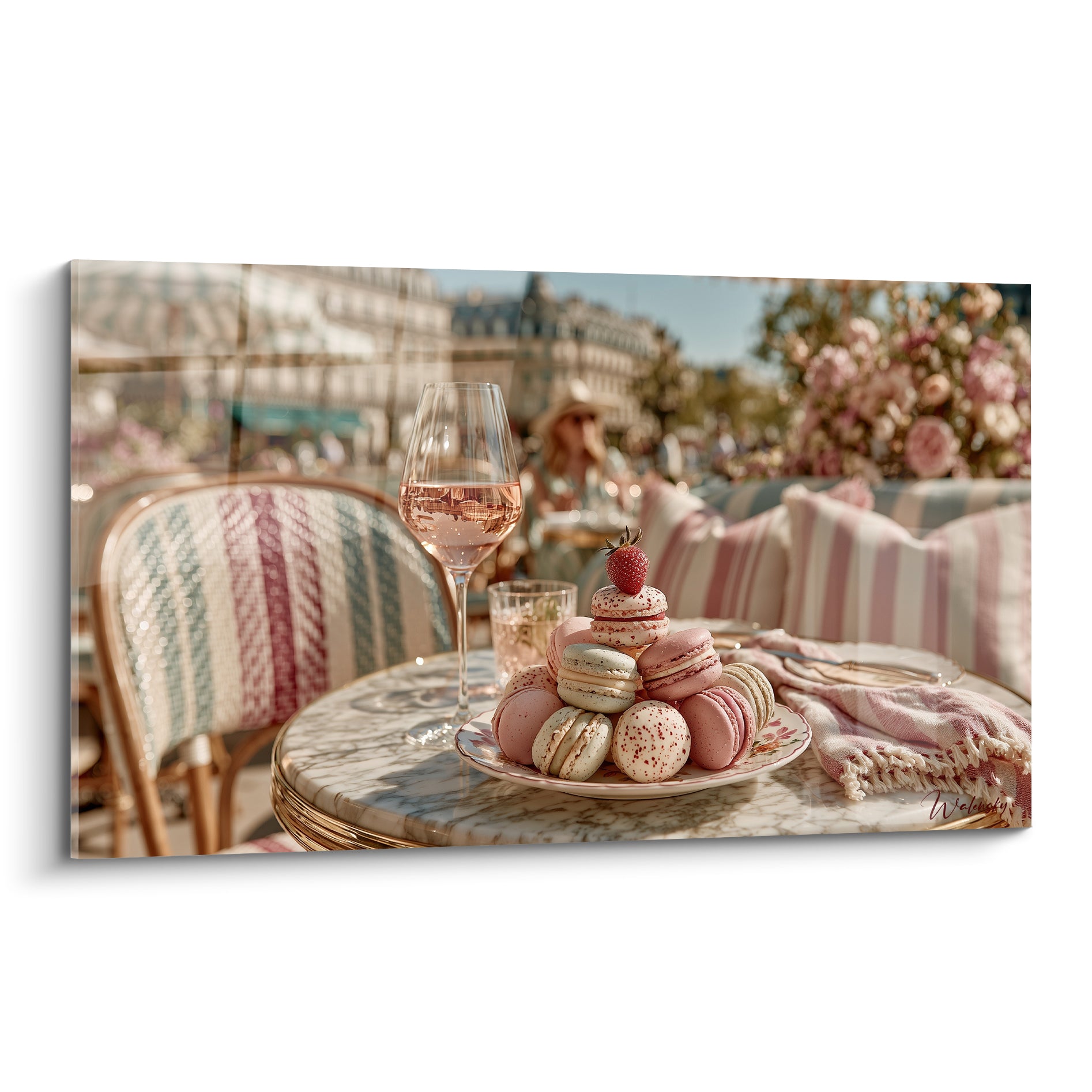 Macarons roses et beiges empilés sur assiette blanche, terrasse parisienne en arrière-plan flou