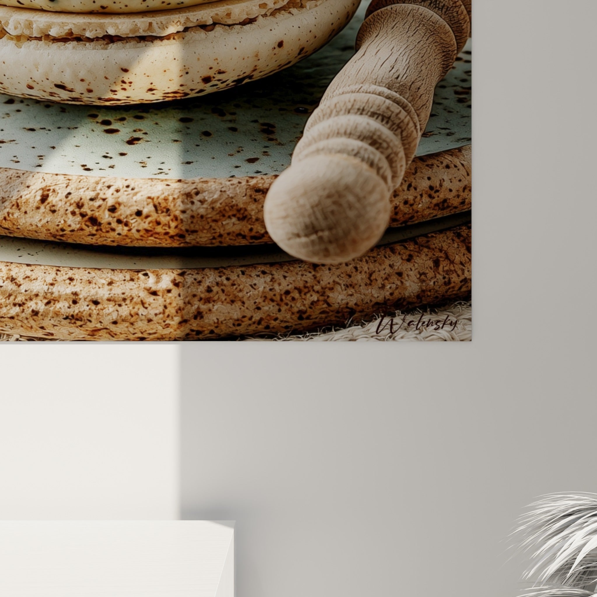 Grain granuleux du macaron ivoire moucheté de brun, texture crémeuse visible entre les coques