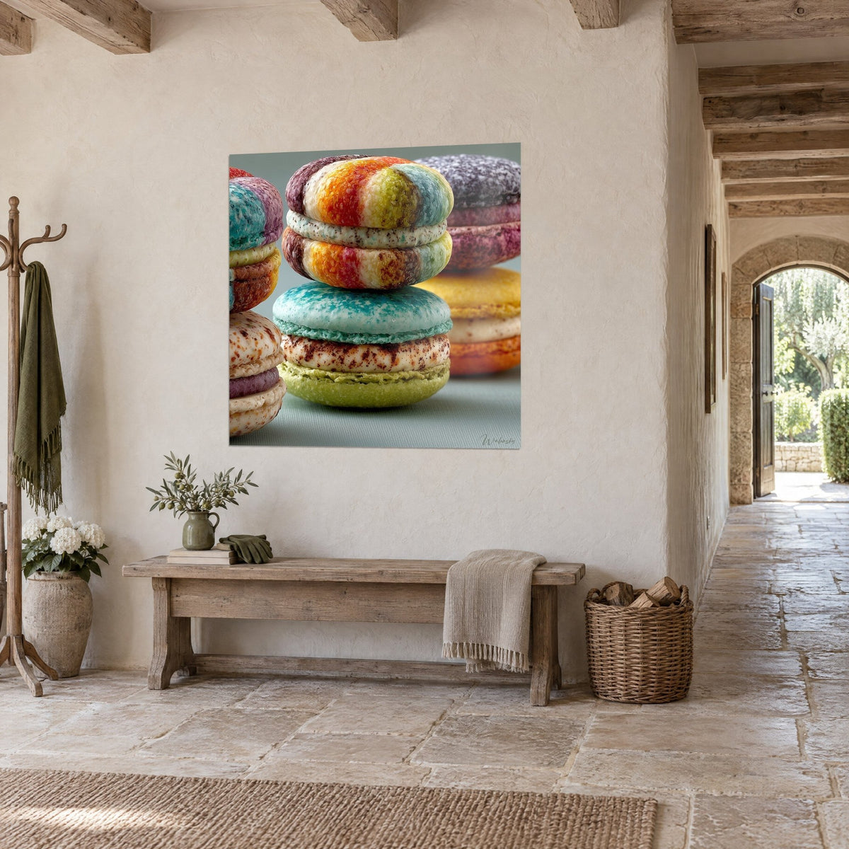 Wall art of colourful pastries stacked, brown dotted cream, grey-green background, hung in a stone hallway, three-quarter view