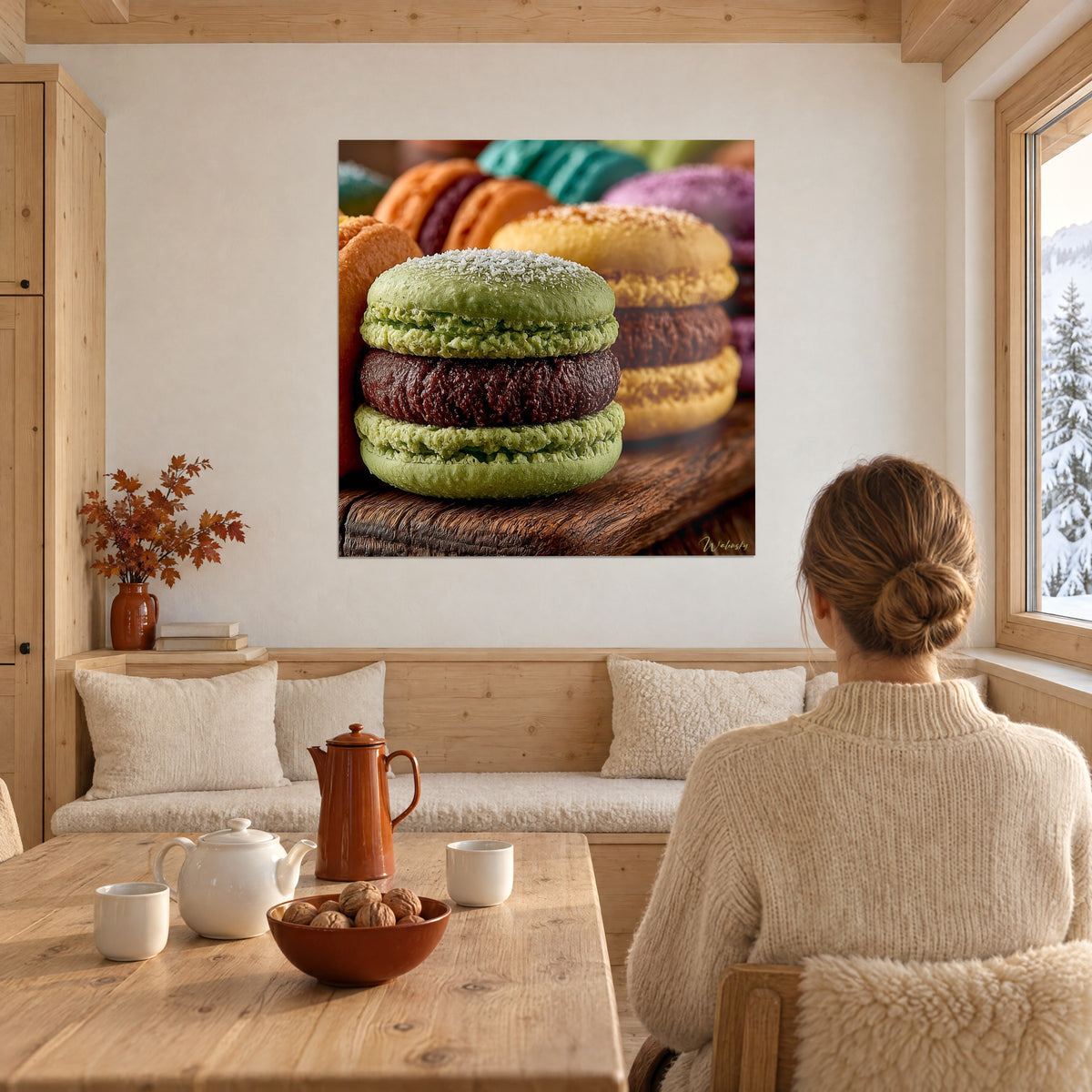 Πίνακας τρίο παγωμένων macarons σε πράσινο, κίτρινο και πορτοκαλί, με γανάχε μπορντό, απέναντι σε γυναίκα με την πλάτη κοντά σε χιονισμένο παράθυρο