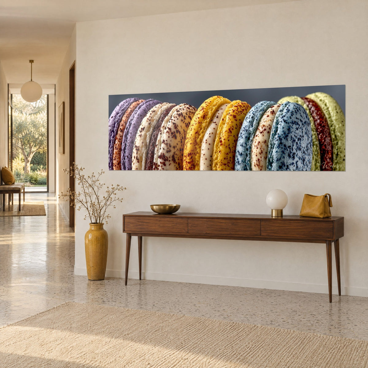 Cuadro disposición compacta de cáscaras de macarons violeta, amarillo azafrán y azul pizarra salpicadas de cacao, sobre una consola de madera