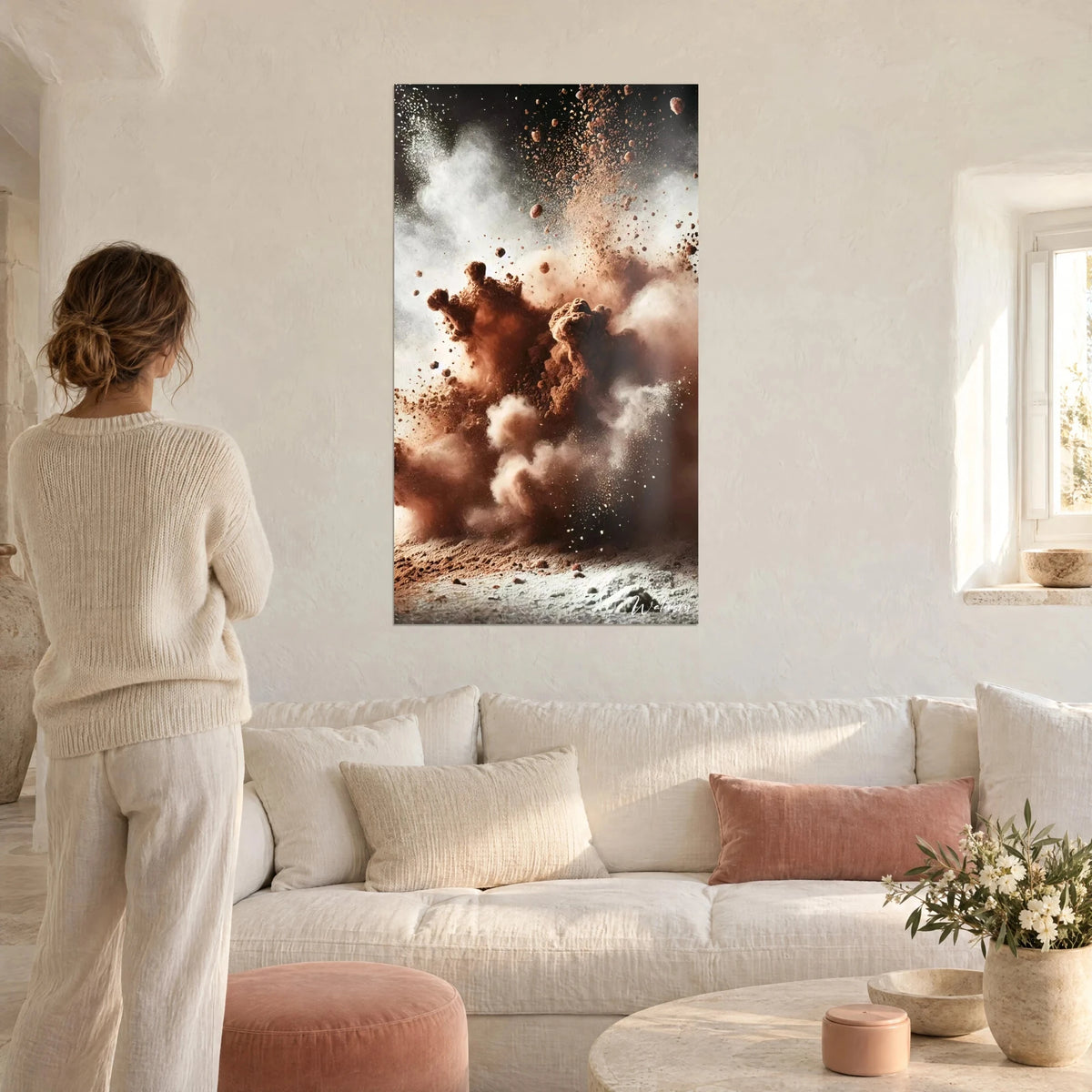 Tableau explosion de cacao en poudre, nuages bruns et blancs, éclats en suspension, femme de dos, au-dessus d'un canapé dans un salon lumineux