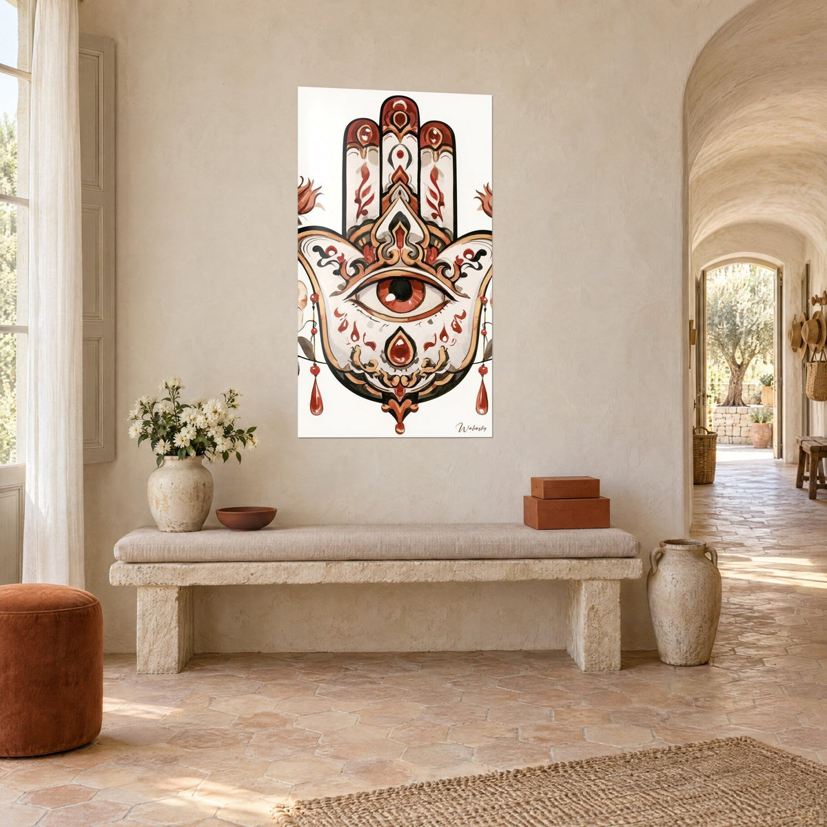 Cuadro amuleto hamsa con tres dedos rojos, ojo central y gotas colgantes, sobre una pared beige junto a un banco de piedra