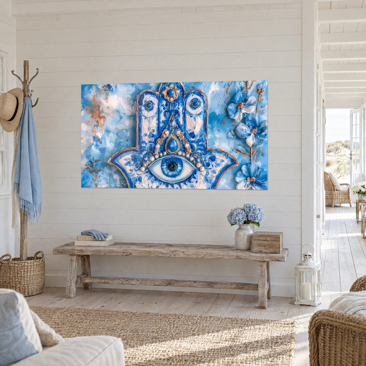 Tableau talisman Khamsa peint en relief, fleurs azur à droite, nuances ocre et blanc, au mur d'une maison de bord de mer