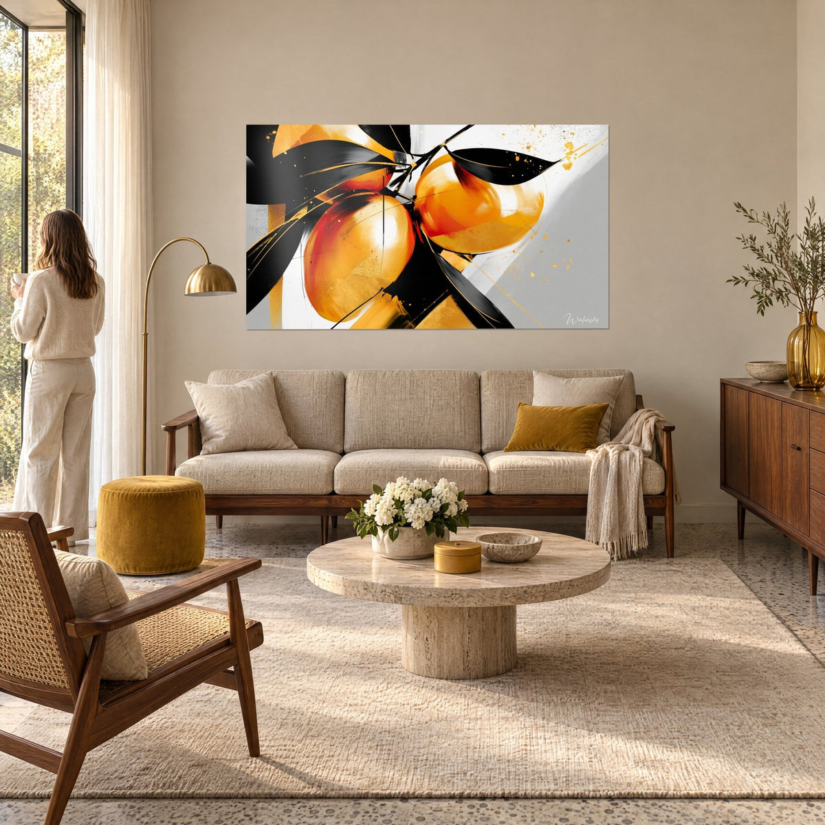 Tableau mangues orange et noir, feuilles d'encre et éclaboussures dorées sur fond gris, au-dessus d'un canapé dans un salon lumineux