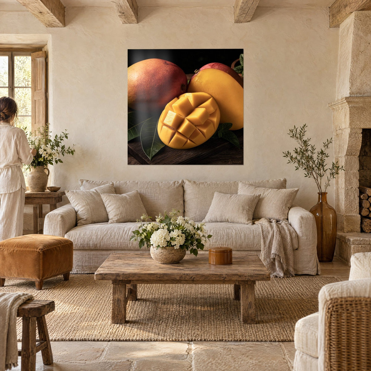 Tableau mangue taillée en cubes dorés, peau rouge et orangé, feuilles vertes, au-dessus d'un canapé dans un salon lumineux