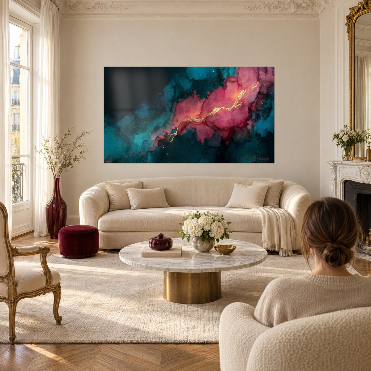 Tableau nuage d'aquarelle rose corail veiné d'or sur fond sarcelle, au-dessus d'un canapé dans un salon lumineux