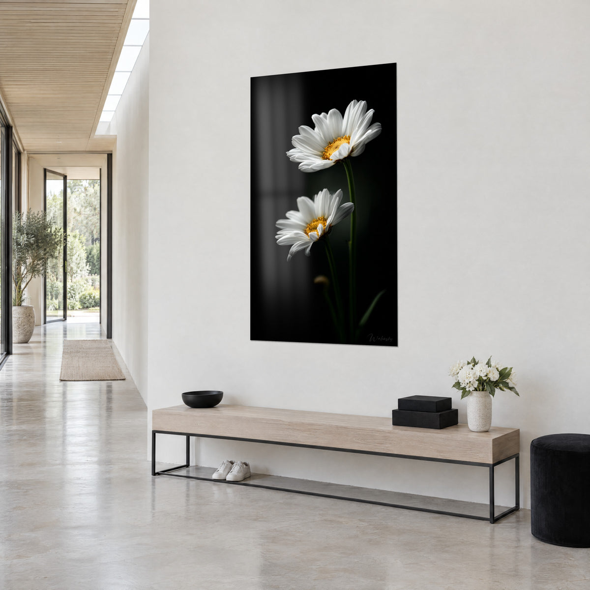 Tableau duo de fleurs aux pétales ivoire et tiges vert sombre sur fond noir, accroché près d'un couloir vitré, vue de trois-quarts