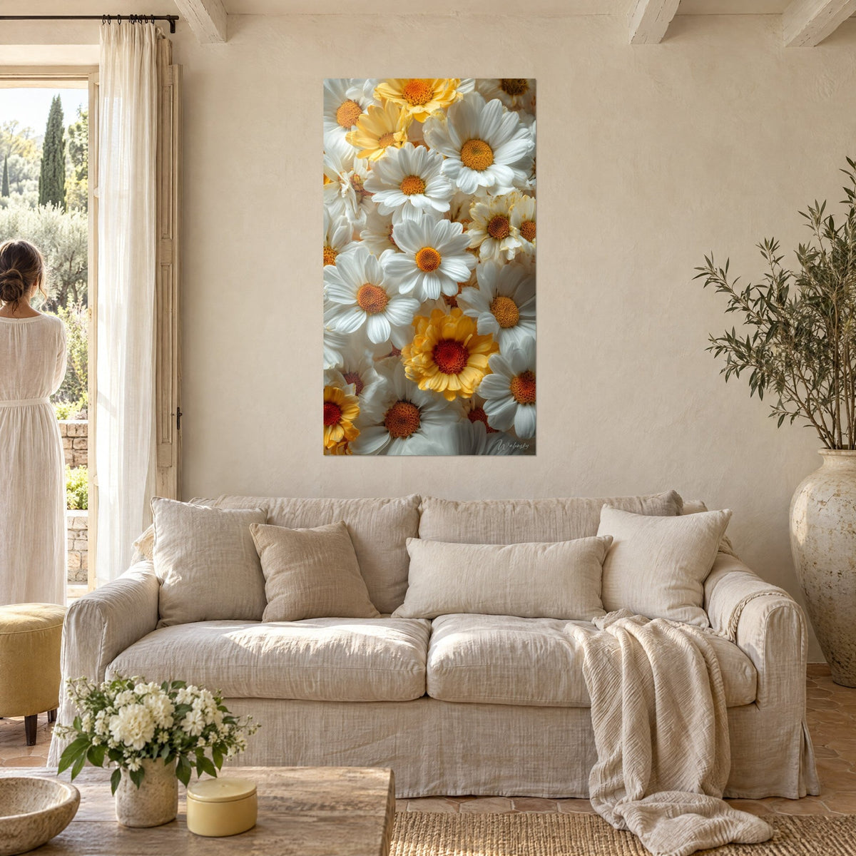 Schilderij met witte margrieten met oranje hart en een gele bloem met goudkleurige bloembladen, boven een bank in een lichte woonkamer