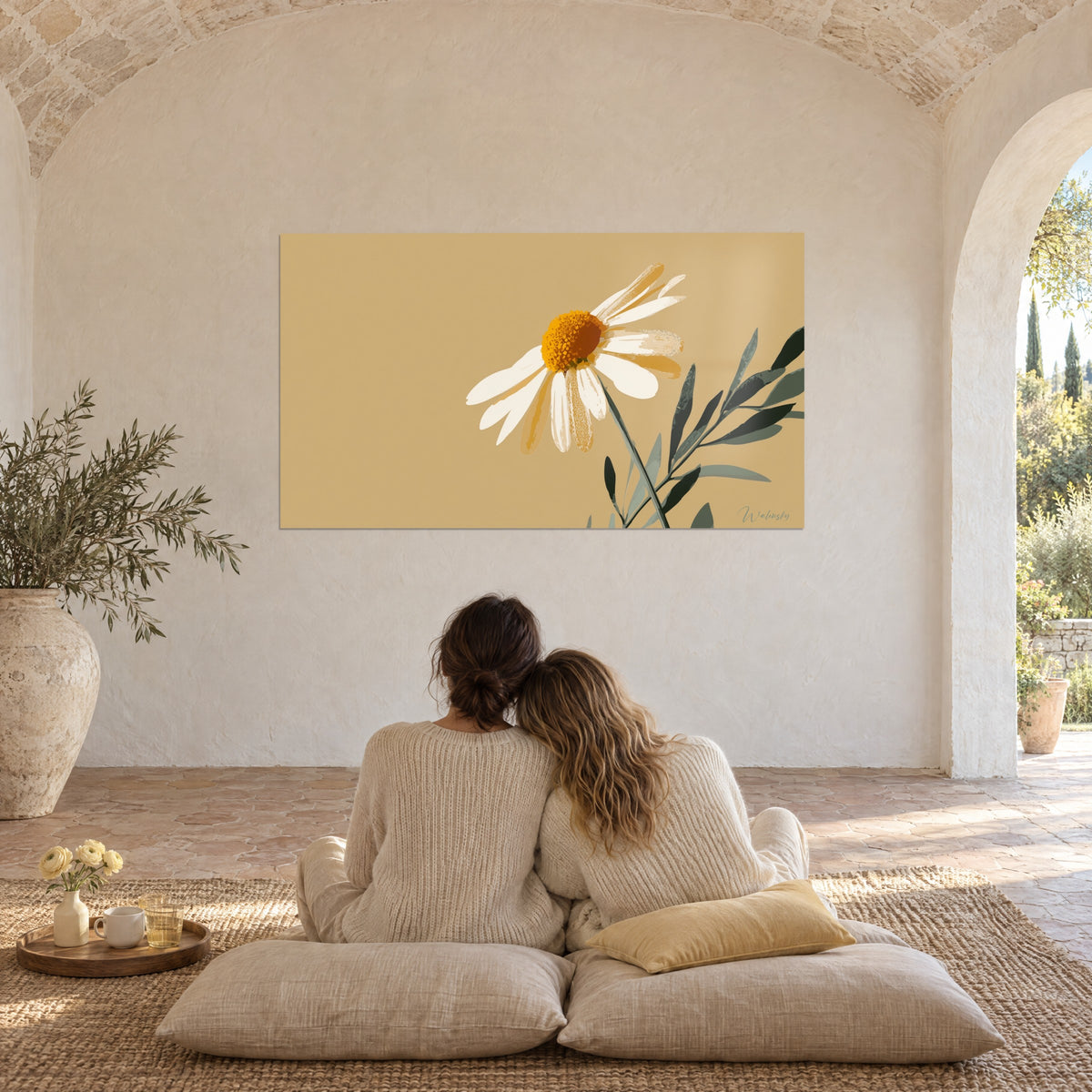 Quadro margherita avorio dal cuore ambrato, foglie grigio-verde su fondo sabbia, coppia abbracciata di spalle su cuscini, volta in pietra
