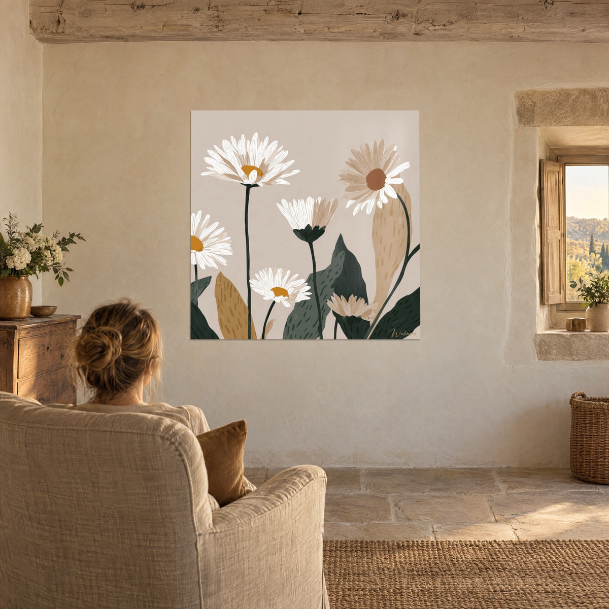 Quadro con fioritura di margherita bianco crema su fondo talpa, fogliame verde profondo, persona di spalle in una poltrona di lino beige