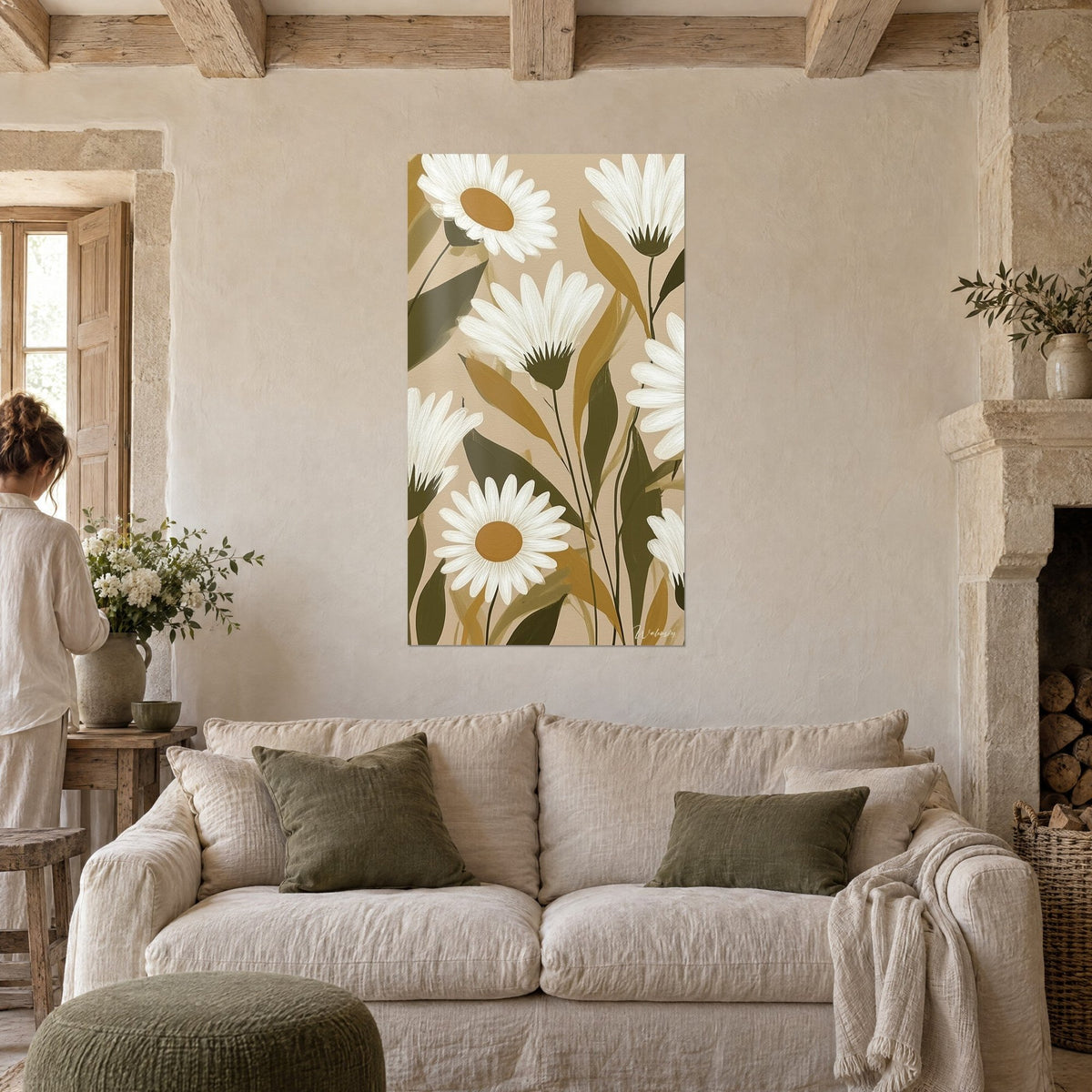 Tableau marguerites blanches aux cœurs ocre sur fond beige, feuillage kaki, personne de dos, au-dessus d'un canapé dans un salon lumineux