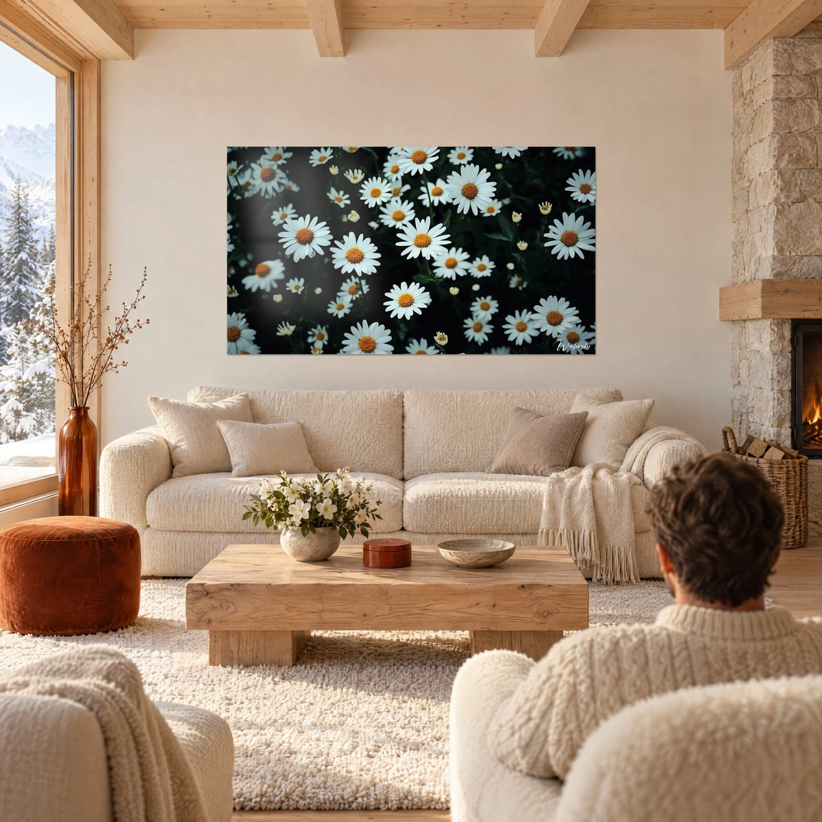 Wall art white daisies with orange centers on a dark green background, above a sofa in a bright living room