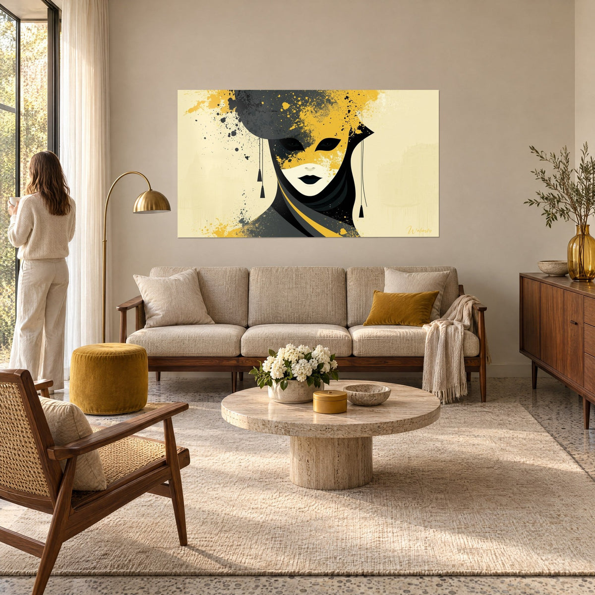 Tableau masque vénitien jaune moutarde et gris anthracite, pointillés noirs, femme de dos, au-dessus d'un canapé dans un salon lumineux