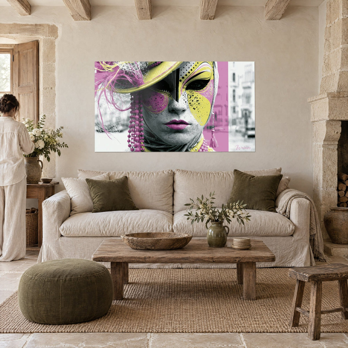Quadro maschera veneziana giallo limone e rosa chewing-gum, cappello con piume, perle rosa, sopra un divano in un soggiorno luminoso