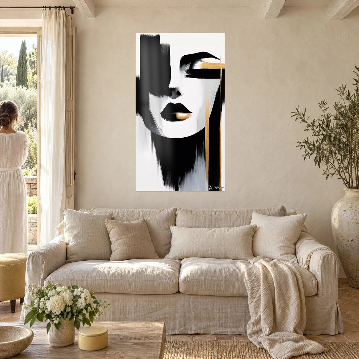 Gemälde Stilisiertes Frauenporträt mit schwarzen Lippen und goldener Linie auf weißem Grund, schwarze Pinselstriche, über einem Sofa in einem hellen Wohnzimmer