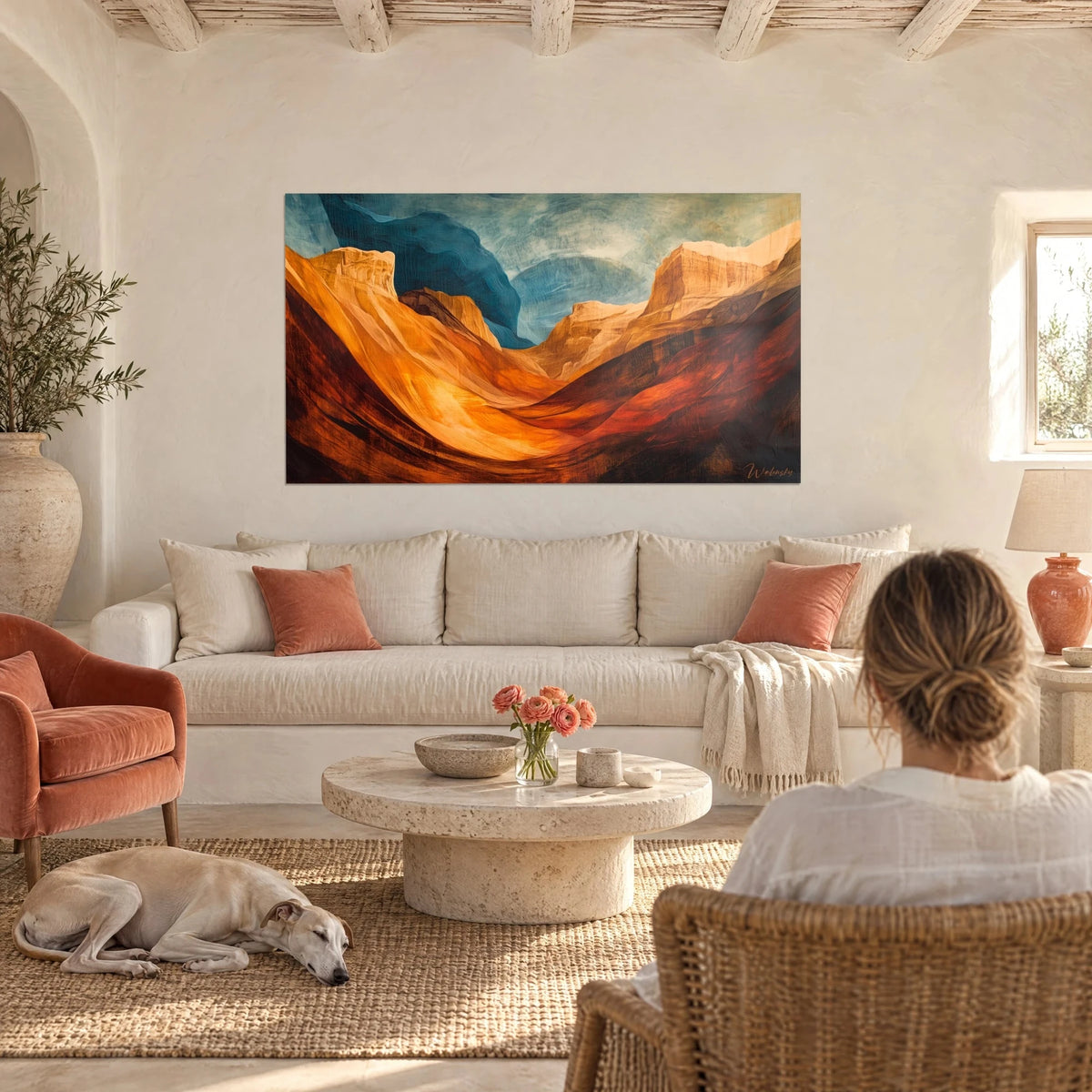 Gemälde Canyon mit ockerfarbenen und bernsteinfarbenen Felsklippen unter einem petrolblauen Himmel, über einem Sofa in einem hellen Wohnzimmer