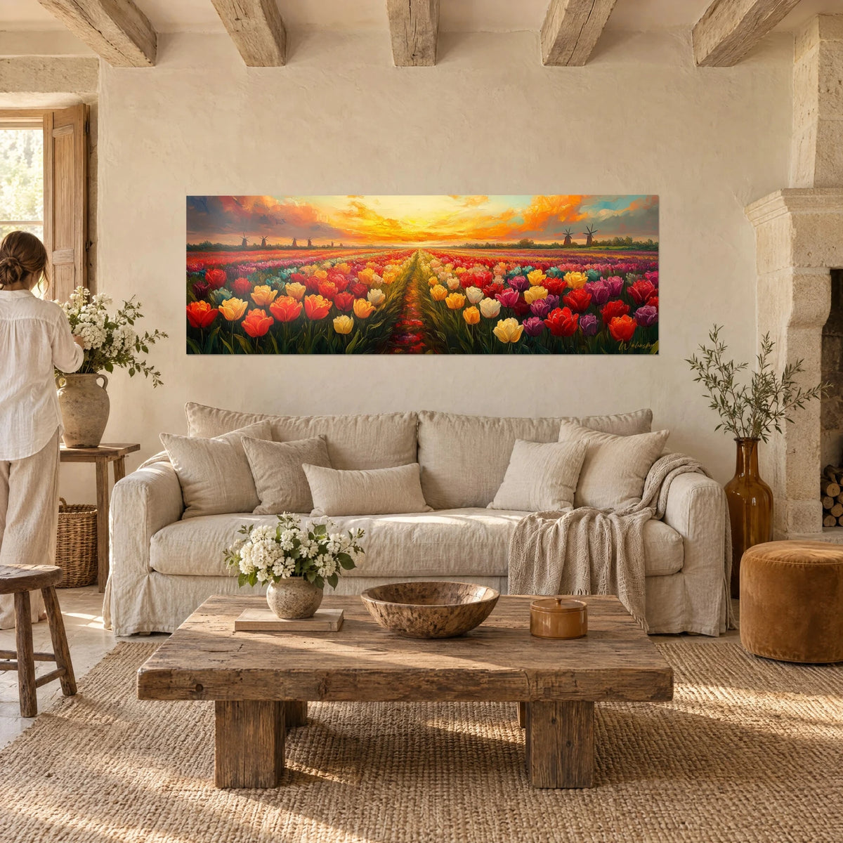 Wall art tulip field in red and yellow under an orange sky, windmills in the distance, above a sofa in a bright living room