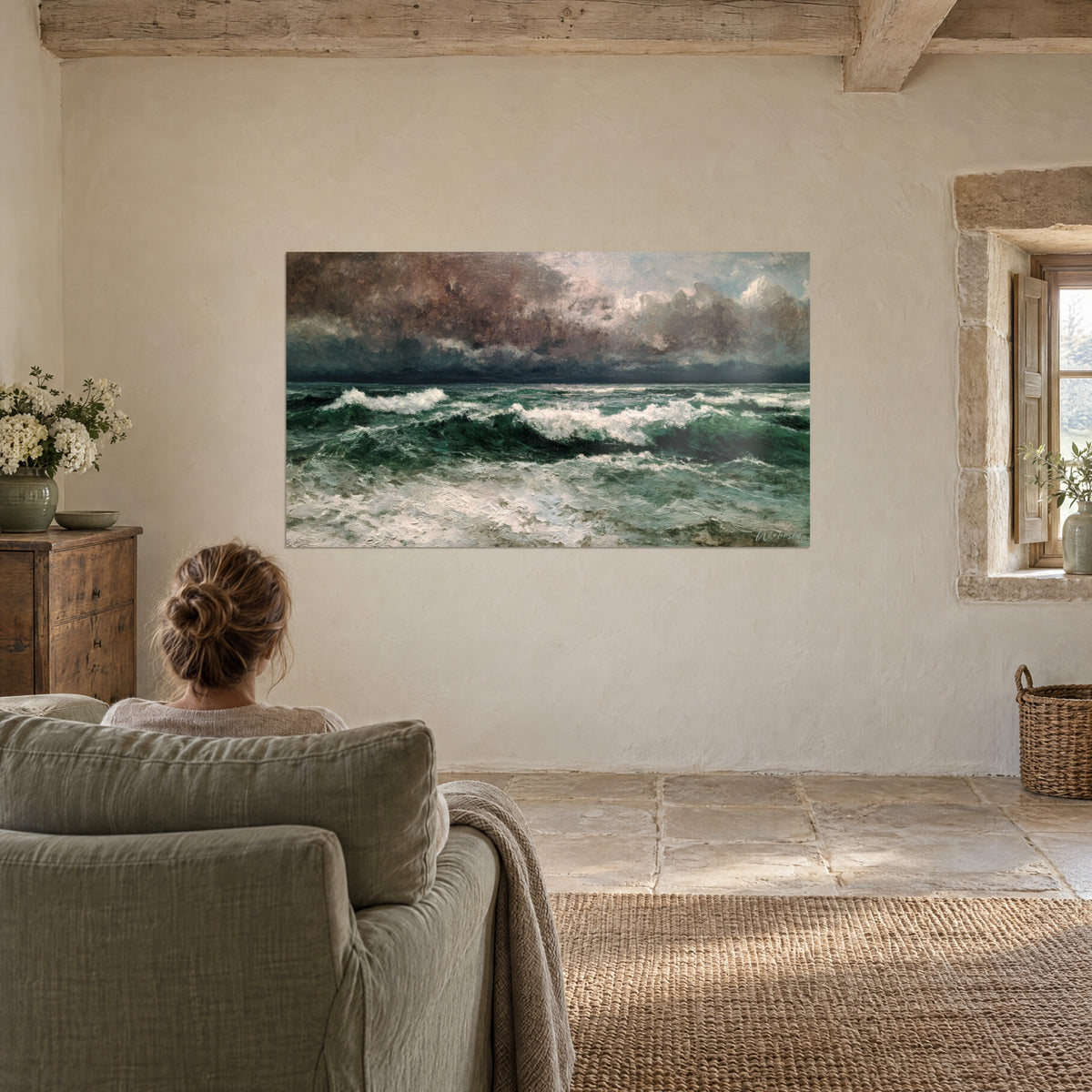 Cuadro mar gruesa bajo las nubes, valles esmeralda, espuma crema y cielo rosado pardo, frente a un sillón en un salón de piedra
