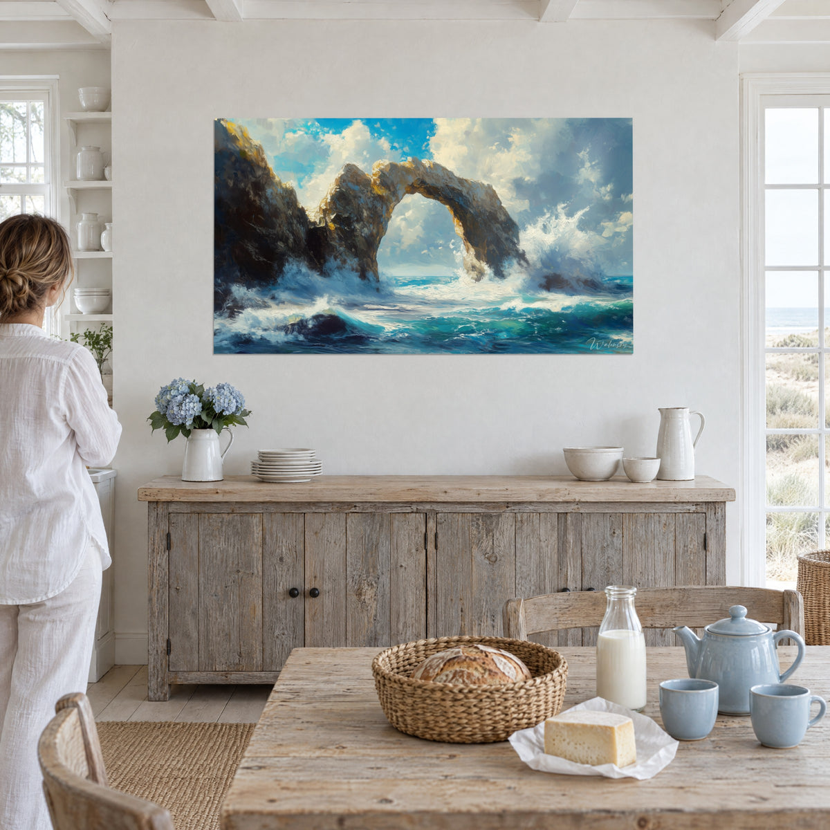 Tableau rocher percé fouetté d'embruns blancs, mer azur et pierre ambrée, face à une femme en blanc dans une maison de plage