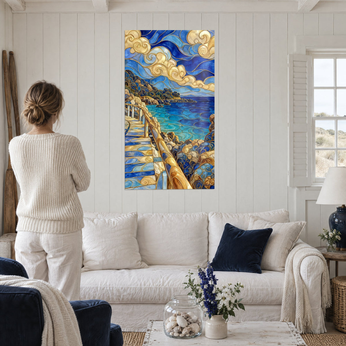 Tableau escalier doré longeant une baie turquoise, nuages ivoire en volutes, au-dessus d'un canapé dans un salon lumineux