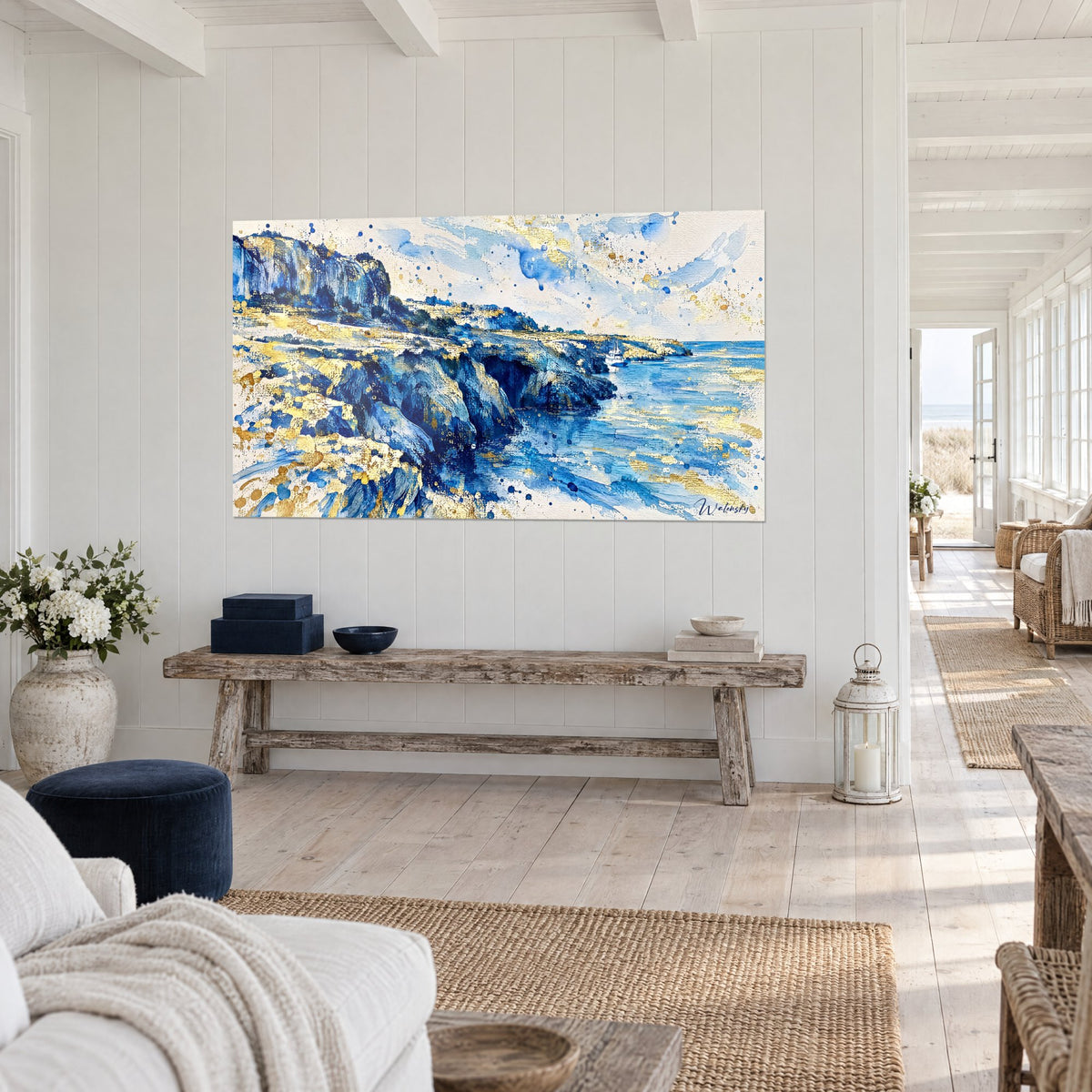 Tableau côte escarpée aux éclaboulures dorées, roche indigo et sable ocre, eau turquoise, sur un mur blanc d'une maison de bord de mer