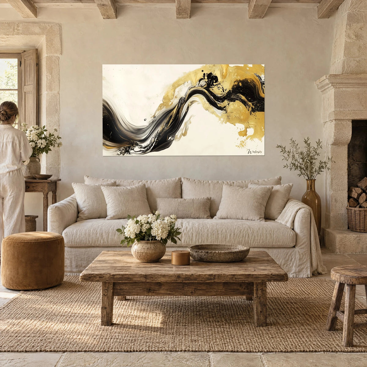 Wall art black and gold paint ribbon on cream background, a woman seen from behind in front, above a sofa in a bright living room