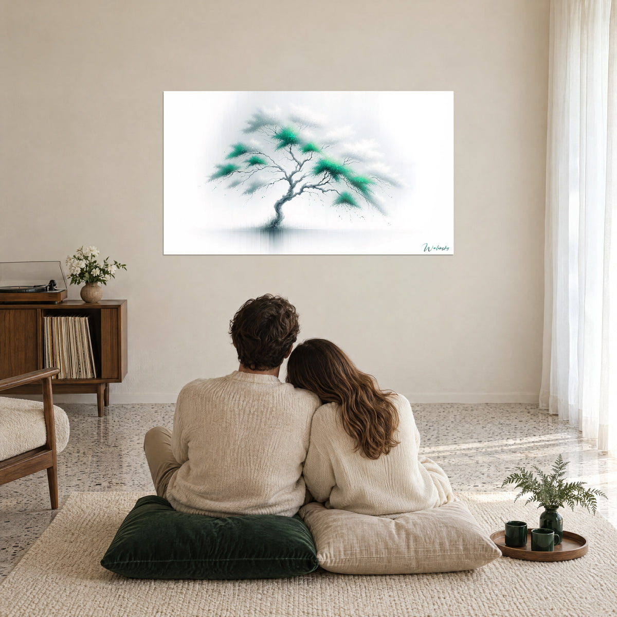 Schilderij uitbundig smaragdgroen gebladerte op een witte mistachtergrond, stel van achteren omhelsd op kussens, rustgevende beige woonkamer