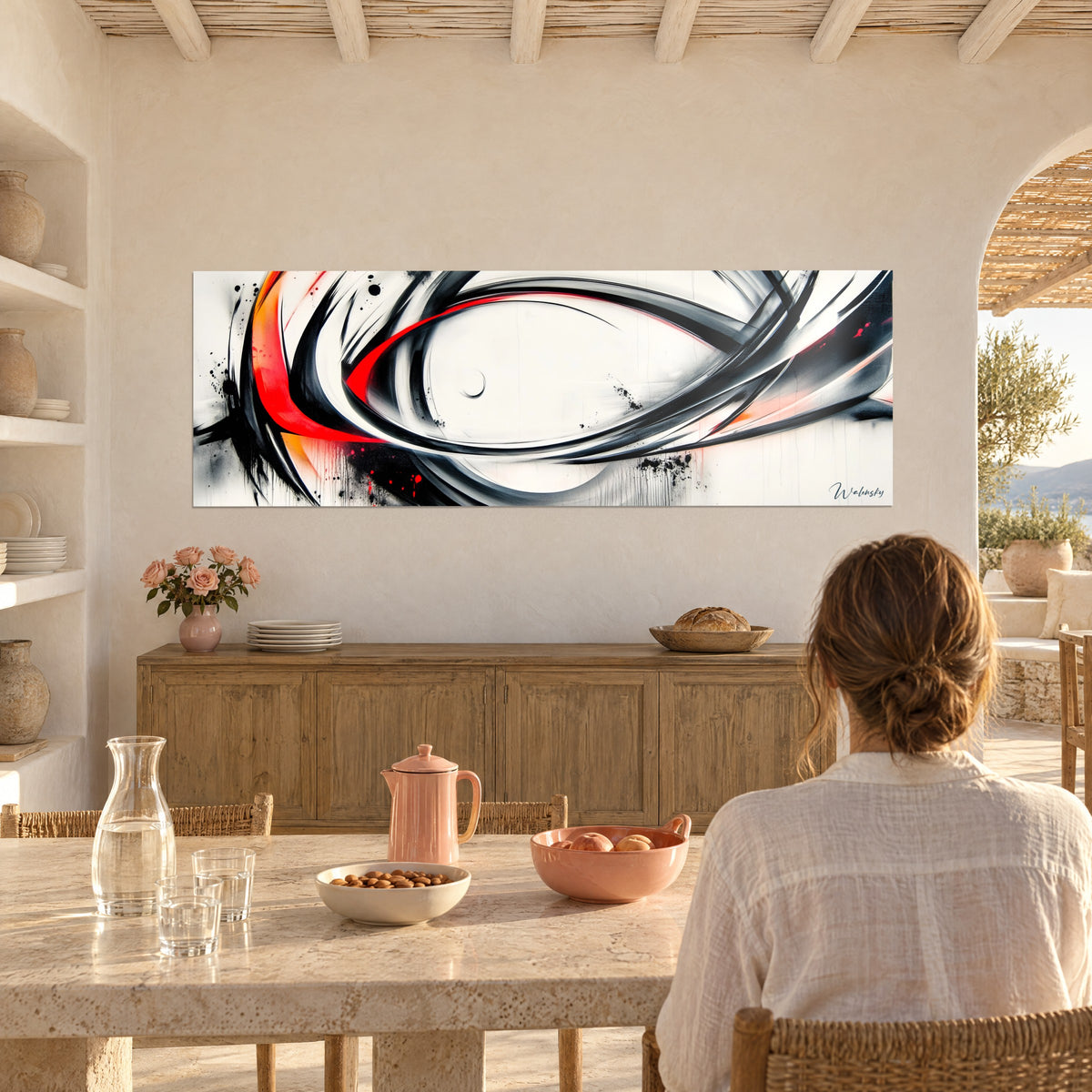 Tableau calligraphie abstraite en boucles de noir profond et rouge écarlate, face à une table en pierre claire d'une maison