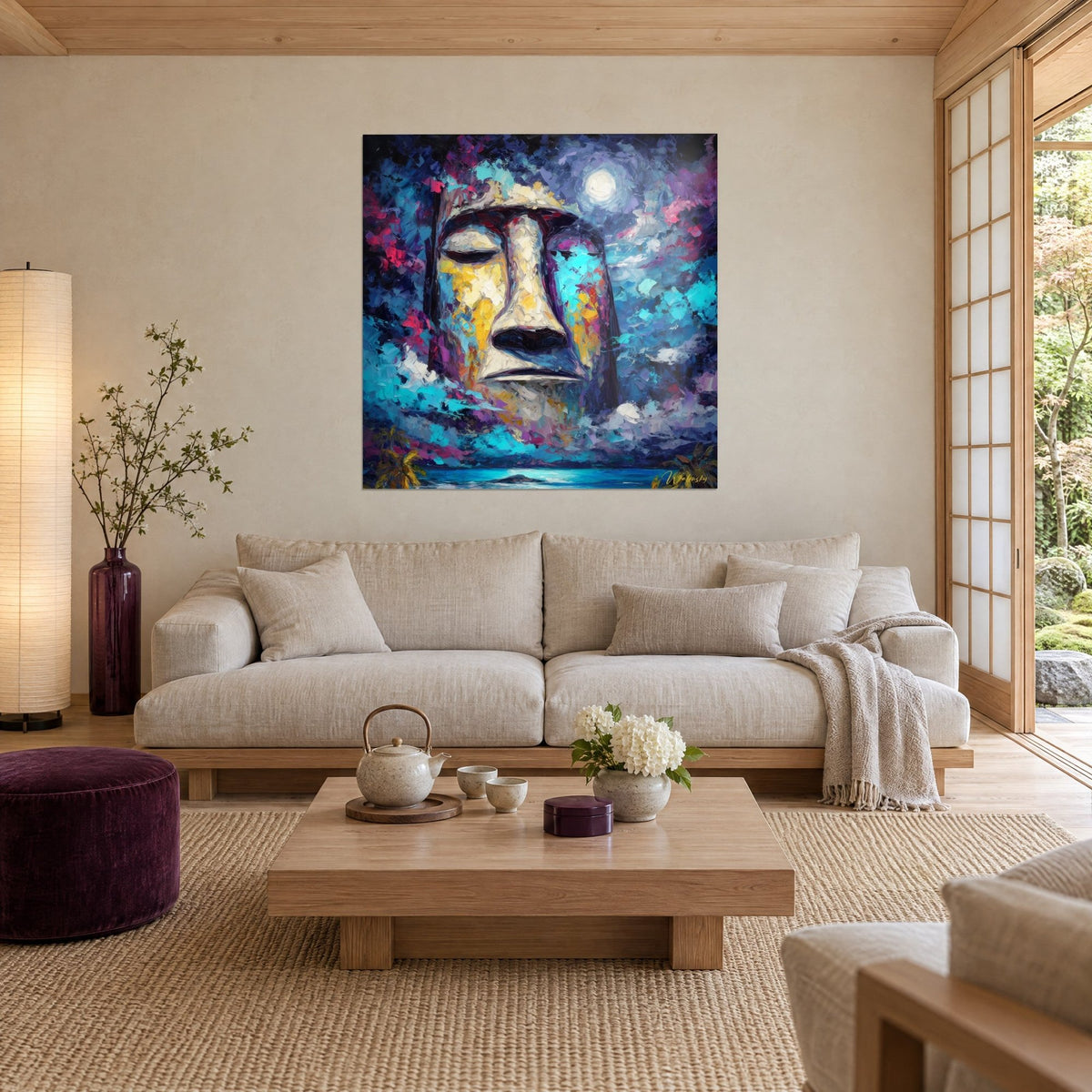 Tableau Moaï endormi sous la pleine lune, visage ivoire strié de jaune et de turquoise, au-dessus d'un canapé dans un salon lumineux