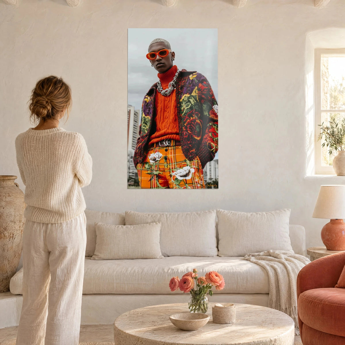 Wall art young model wearing orange glasses and a silver chain, purple and green floral jacket, above a sofa in a bright living room