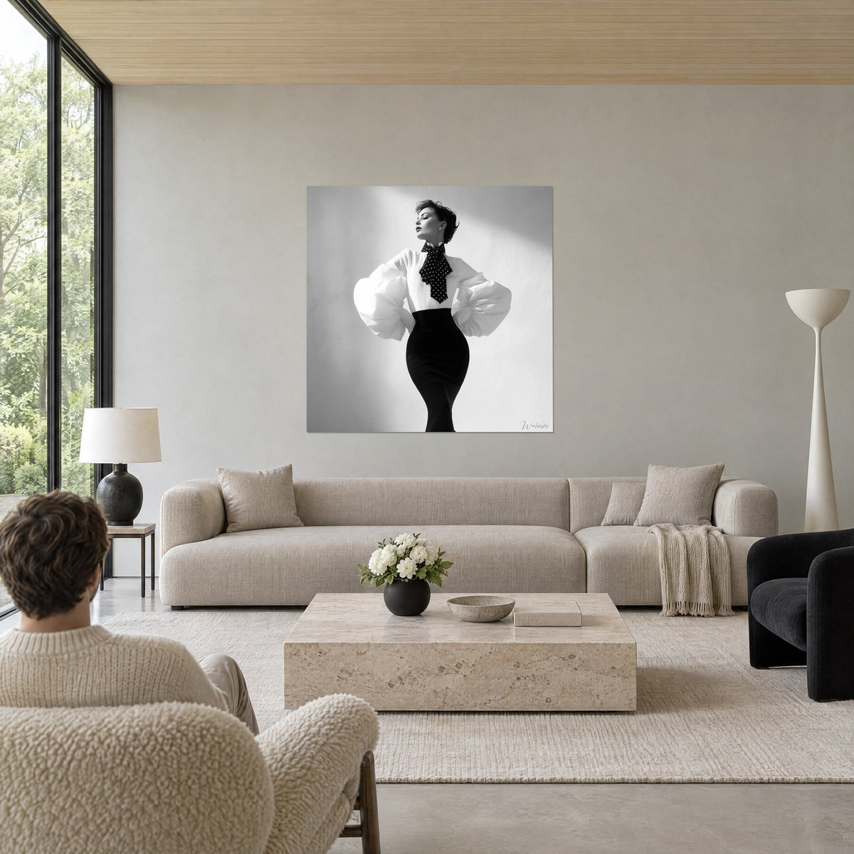 Tableau mannequin au foulard à pois, manches bouffantes blanches sur jupe fourreau noire, au-dessus d'un canapé dans un salon lumineux
